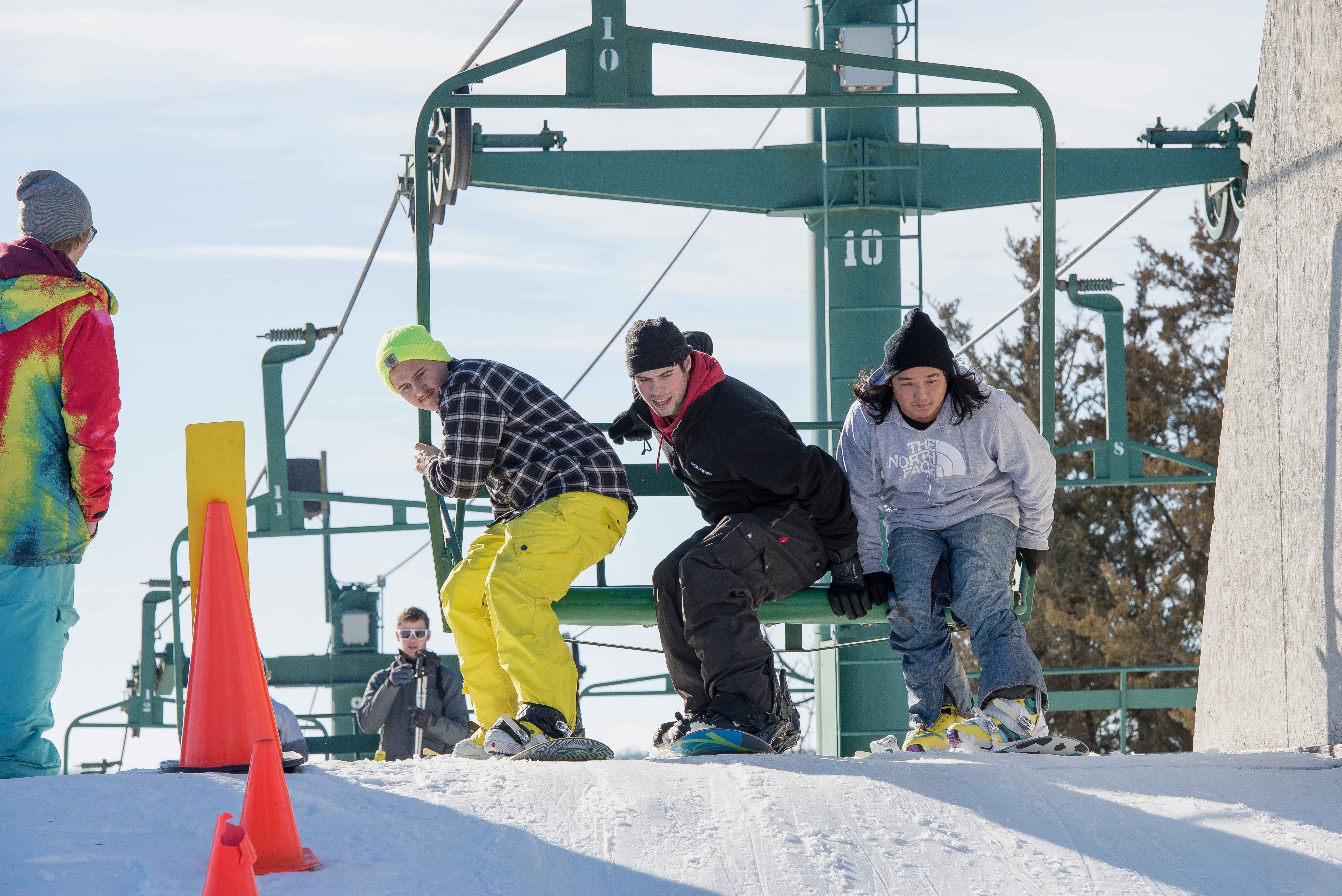 snowboarders getting off lift.